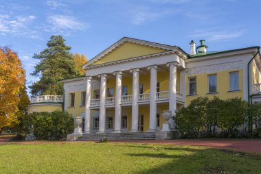 An old two-storey manor house with columns in autumn. Large clearing in front of the house. Gorky Leninskie, Lenin hills, Russia, the last location of Vladimir Lenin. clipart
