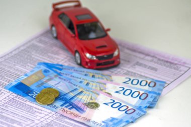 Rusya, tanılama kartı muayene makinesi, araba sigortası. Kırmızı araba biçimidir. Birkaç Rus banknotlar 2000 ruble değer. En yakın sikkeleri üzerinde odaklanmak.