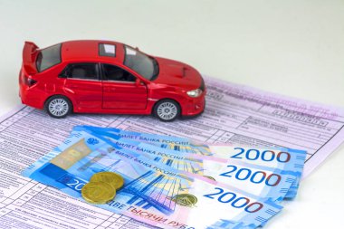 Rusya, tanılama kartı muayene makinesi, araba sigortası. Kırmızı araba biçimidir. Birkaç Rus banknotlar 2000 ruble değer. En yakın sikkeleri üzerinde odaklanmak.