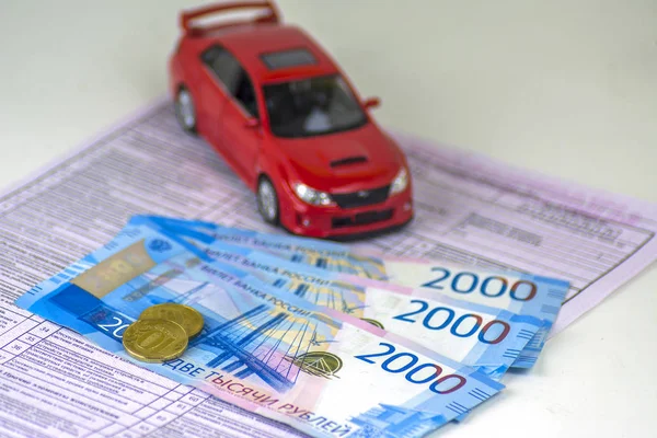 Rusya, tanılama kartı muayene makinesi, araba sigortası. Kırmızı araba biçimidir. Birkaç Rus banknotlar 2000 ruble değer. En yakın sikkeleri üzerinde odaklanmak.
