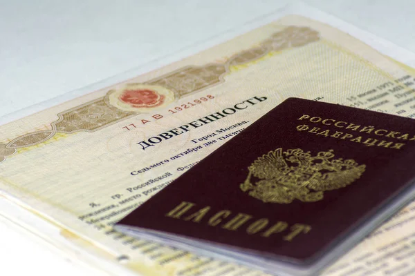 Rus belgeleri. Başka bir kişiye vekalet noterlik sekli. Rus pasaportu üstüne yatıyor. Beyaz arka plan üzerinde