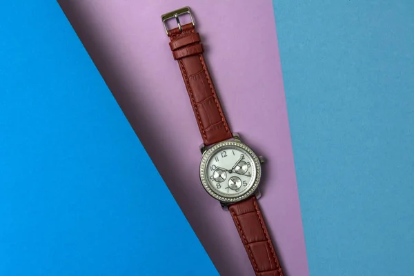 Zegarek Rękę Moda Damska Fioletowym Tle Niebieski Arkusz Szybuje Nad — Zdjęcie stockowe