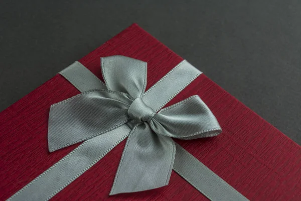 弓灰色背景の美しい赤いギフト ボックス クローズ アップ — ストック写真