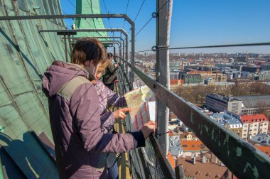 Tallinn, Estonya, 2017 02 Mayıs. Turistler harita Oleviste kilise gözlem güvertesinde bahar zaman görüntülemek