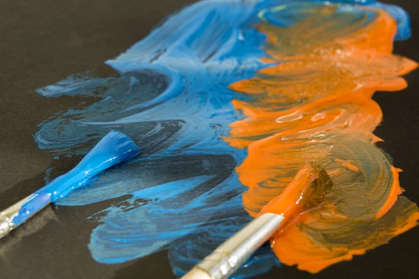 Twee Borstels Lijnen Verven Zwart Papier Blauwe Oranje Kleuren — Stockfoto