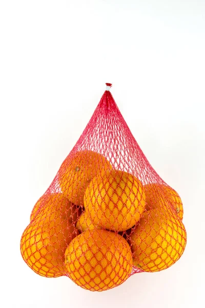 Oranges are Packed in a grid. Hanging grid with citrus fruits. — Stock Photo, Image