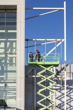 Moskova, Rusya, 02 Nisan 2019. Montaj işçileri binanın cephe önünde kaldırma platformu üzerinde çalışıyor