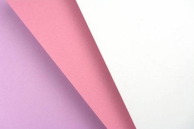Üst üste yatan renkli kağıt tabakaları. Kağıt pembe, mor ve beyaz