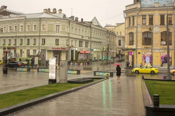 Москва, Россия, 17 июля 2019 года. Летний дождь в Москве, женщина с зонтиком идет по улице — стоковое фото