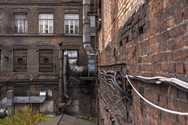 The courtyard of the old factory. Old brick walls with padded cables — Stock Photo, Image