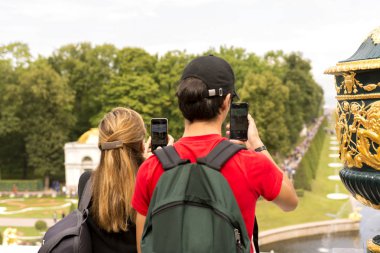 Peterhof, Rusya, 08 Ağustos 2019. Turistler cazibe fotoğraf çekmek. Akıllı telefona odaklanın.