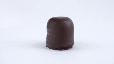 Çikolata kaplı marshmallow - choco softies dönüş tablo üzerinde döner. Beyaz arka plan üzerinde izole.