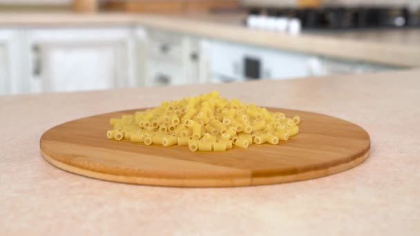 Куча ditali tubetti rigati pasta on the plate. Вращающаяся камера с белой кухней на заднем плане. Долли-шот . — стоковое видео