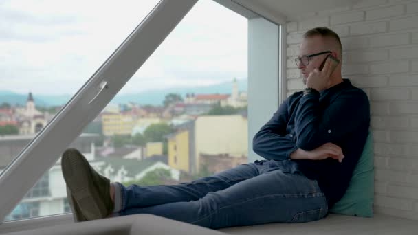 Der Junge Mann Sitzt Fenster Spricht Mit Dem Handy Altstadt — Stockvideo