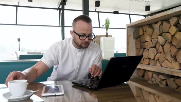 Joven Barbudo Con Gafas Trabajando Cuaderno Tableta Descanso Bebe Café — Vídeos de Stock