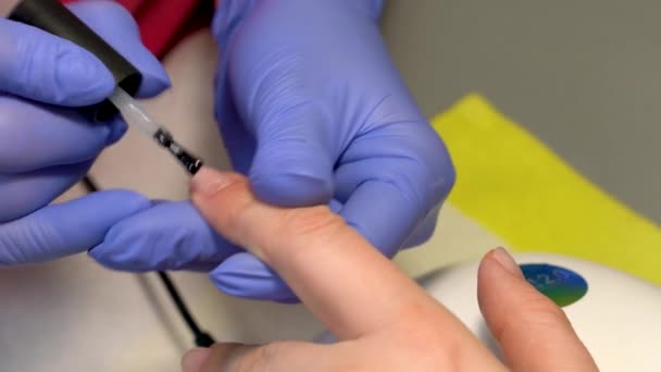 Closeup of applying regular rehydrating base coat for manicure. Rich filler base. Polish foundation. — Stock Video