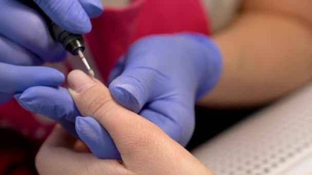 Close-up van het verwijderen van nagel nagelriemen en vingernagel polijsten met behulp van elektrische manicure boor machine. Hardware droge manicure proces in de schoonheidssalon. Blauwe glowes. — Stockvideo