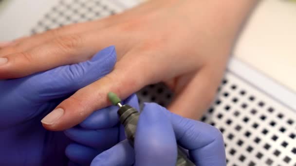 Close-up van het verwijderen van geile huidlaag met behulp van elektrische manicure boor machine. Hardware droge manicure proces in de schoonheidssalon. Blauwe glowes. — Stockvideo