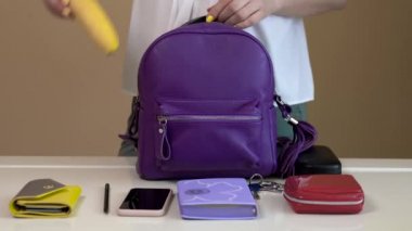 Genç bir kadın dışarı çıkmadan çantasını toplar. Bayanlar çantasının içindekiler.