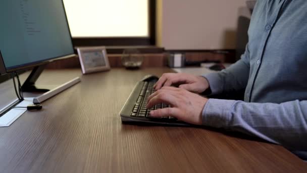 Hombre significativo manos en una camisa azul escribiendo en el teclado. Escribir un documento en el software de oficina del editor de documentos. Mesa de madera. Vídeo de imágenes deslizantes motorizadas . — Vídeo de stock