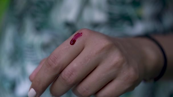 Close-up van de hand van een vrouw met een dun straaltje van bloed stroomt. — Stockvideo