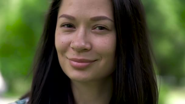 Ett porträtt av en Söt asiatisk kvinna blinkar med ögonen. Närbild. — Stockvideo
