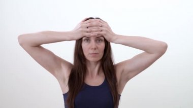 Alin satır kırışıklık tedavisinde yüz egzersiz yaparak bir kadın portresi. Beyaz arka plan üzerinde izole.