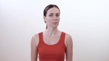 Sol ve sağ baş dönme esmer bir kadın portresi. Boyun için güçlendirilmesi egzersiz yapmak. Beyaz arka plan üzerinde izole.