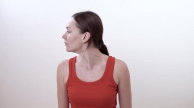 Sol ve sağ baş dönme esmer bir kadın portresi. Spazm kaldırma boyun kasları için egzersiz yapmak. Beyaz arka plan üzerinde izole.