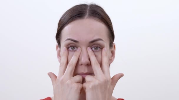 上部の瞼を強化するための運動をしている笑顔のブルネットの女性の肖像画 白い背景に分離 — ストック動画