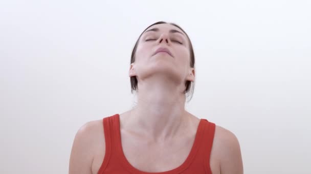关闭一个黑发女人做圆形运动头部 为颈部肌肉做痉挛切除运动 在白色背景上被隔离 — 图库视频影像