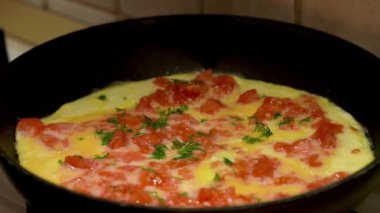 Tavada domates pişmiş yumurta pişirme yakın. Taze otlar ekleme.