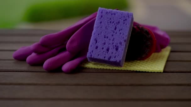 Camera finds a rag, sponge, brush, gloves putting on the wooden table. Close up. Macro. — Stock Video