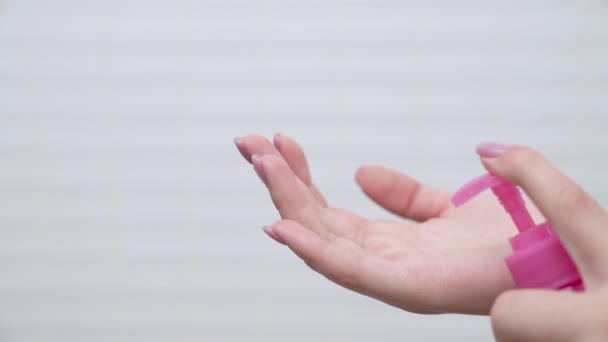 Vrouw handen duw omlaag fles pomp te knijpen een transparante vloeistof aan de andere kant. Witte kleur achtergrond. Closeup — Stockvideo