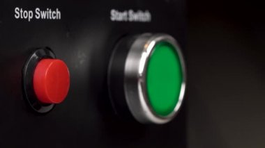 Çerçeve içinde iki düğme closeup. Yeşil Başlat düğmesi ve kırmızı stop düğmeleri değiştir. Parmak basın kırmızı Dur düğmesini.