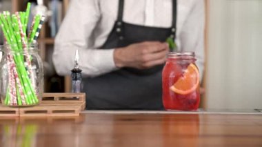 Taze, güzel bir kırmızı renk limonata barda yapma bitirme yakışıklı genç barmen el yakın çekim sayaç.