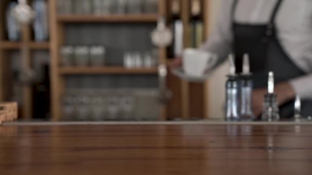 Penutup barista menempatkan secangkir kopi panas segar ke meja bar . — Stok Video