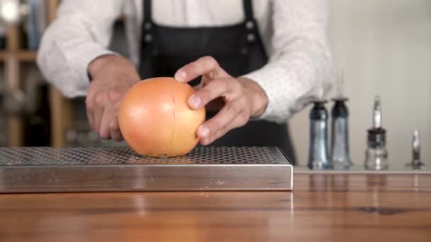 Primer plano de manos de camarero corta el pomelo en el mostrador de la barra, antes de hacer un en el cóctel . — Vídeos de Stock