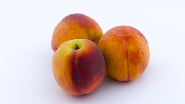 Три персикові плоди. Обертається на поворотній стіл. Ізольовані на білому тлі. крупним планом . — стокове відео