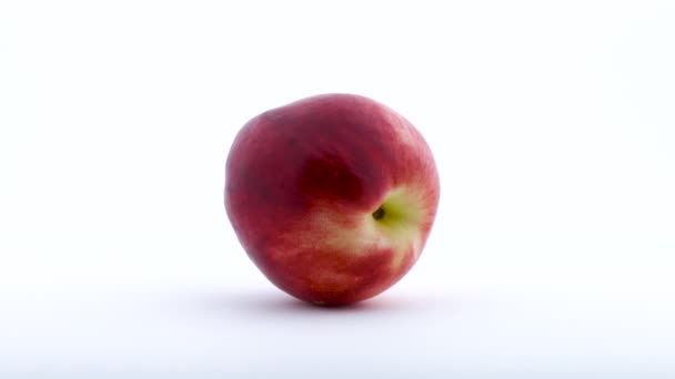 Una fruta entera de nectarina está girando en el plato giratorio. Aislado sobre el fondo blanco. De cerca. . — Vídeo de stock
