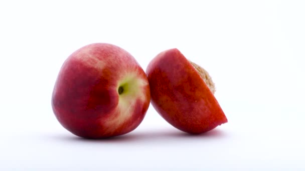 One and the half of nectarine fruit. Rotating on the turntable. Isolated on the white background. Close up. — Stock Video