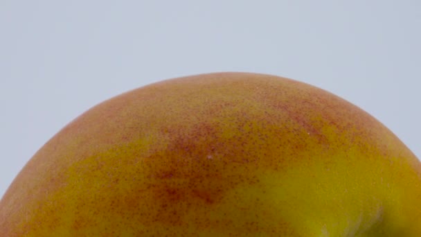 Sluit super macro van een hele perzik fruit. Draaien op de draaitafel. Geïsoleerd op de witte achtergrond. — Stockvideo