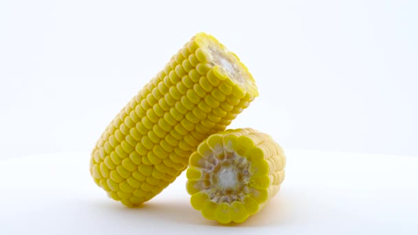 Dos mitades de maíz dulce fresco pelado. Girando en el tocadiscos. Aislado sobre el fondo blanco. De cerca. Macro . — Vídeo de stock