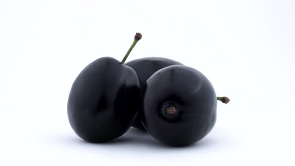 Three whole plum fruits. Rotated on the turntable. Isolated on the white background. Close up. — Stock Video