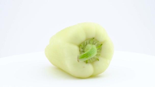 One long white banana pepper in water drops. Rotating on the turntable. Isolated on the white background. Close up. Macro. — Stock Video