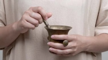 Kadının elele bir harç ve havaneli. O yavaşça yaprakları gül ' havaneli twirling mortaring.