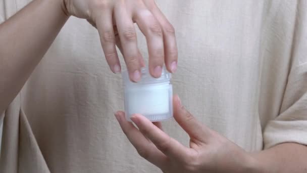 Un primo piano delle mani di una donna che apre un barattolo con la crema. Poi la richiude. . — Video Stock