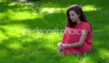 Güzel bir genç kadın çimlerde oturuyor. O dizlerinin hemşireler. Kamera yavaş yavaş soldan sağa taşır..