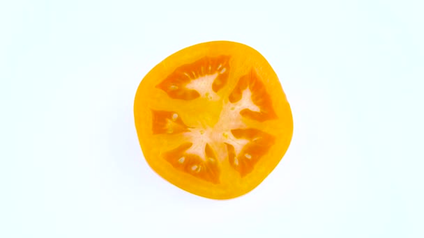 从上面的橙色西红柿的最高视图。截面。在白色背景上被隔离的转盘上旋转。特写。宏观. — 图库视频影像