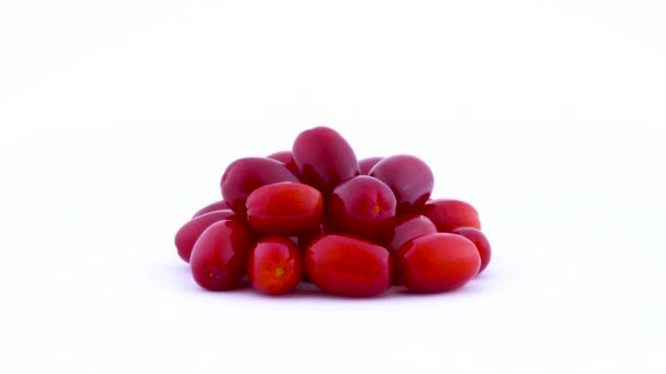 Pile of cornelian cherry dogwood fruits rotating on the turntable isolated on the white background. Side view. Close up. — Stock Video